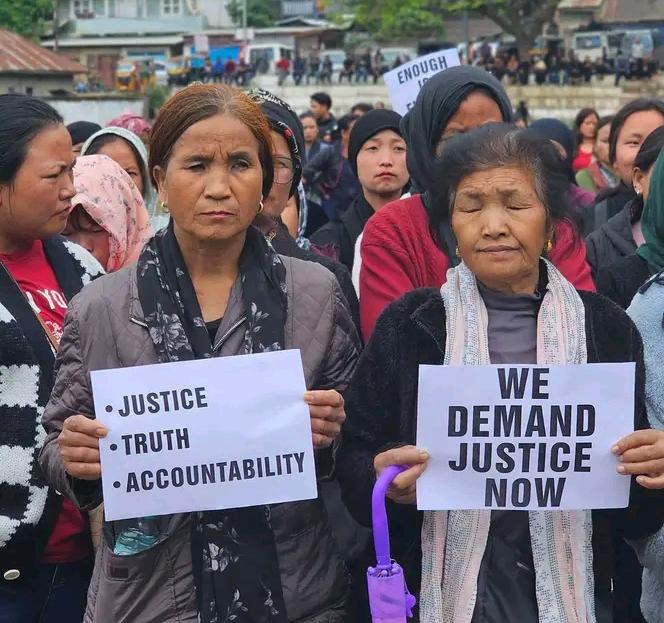 Women holding protest placards during a justice rally in Manipur.