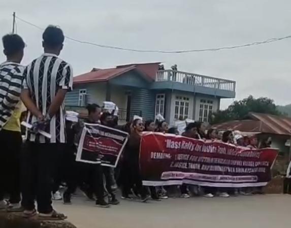 Crowd gathered with banners during a protest march related to violence in Manipur.
