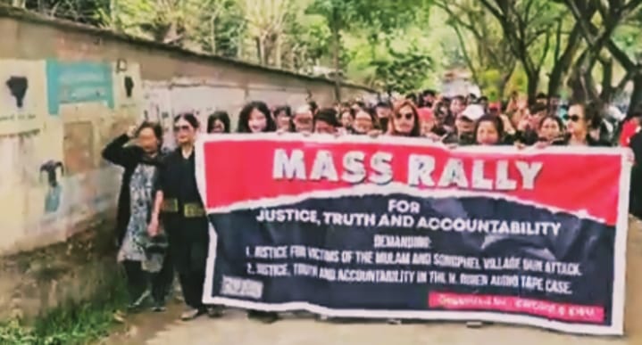 People marching with a large justice and accountability banner during a rally.