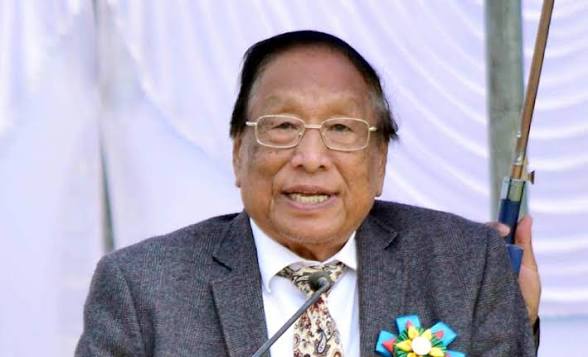 naga leader speaking at event microphone formal setting