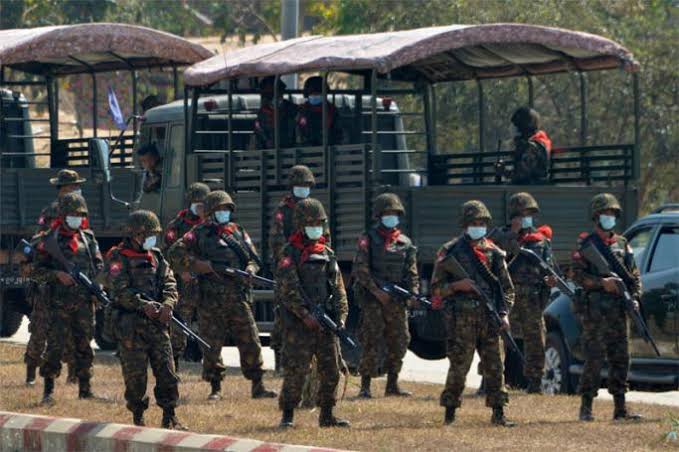 Myanmar soldiers standing near military vehicles during border security operations