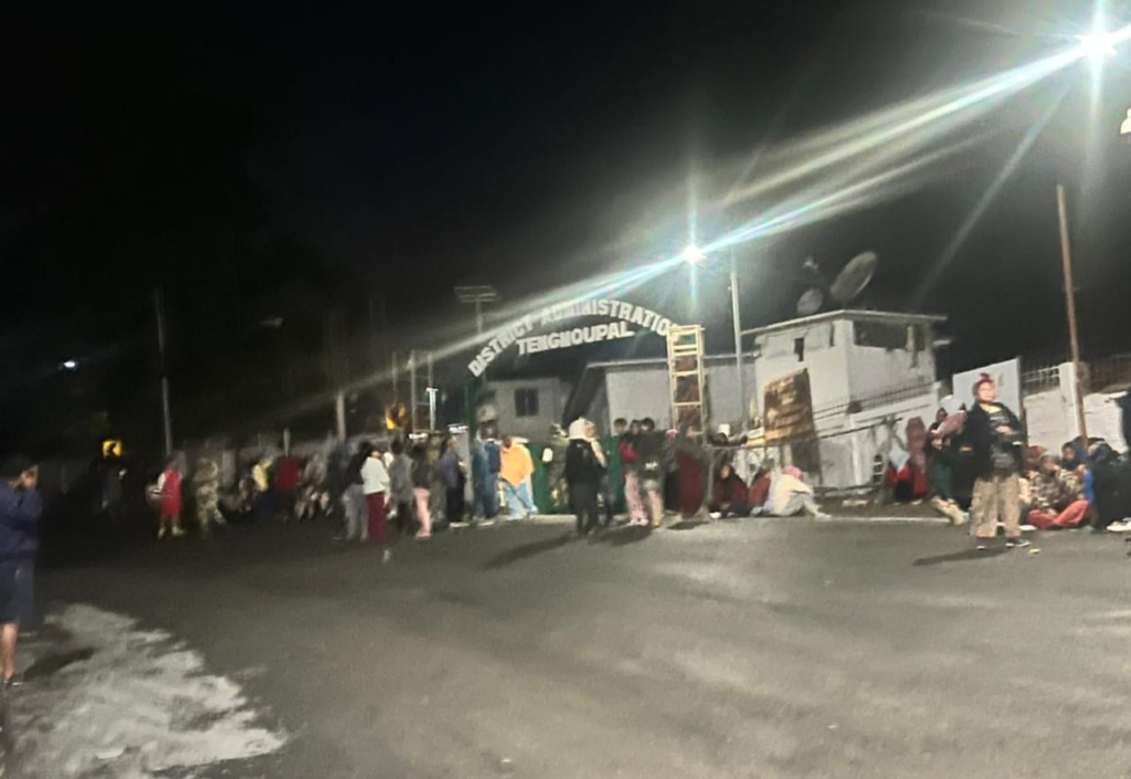 Large crowd gathered near a police station at night during a shutdown in Moreh.
